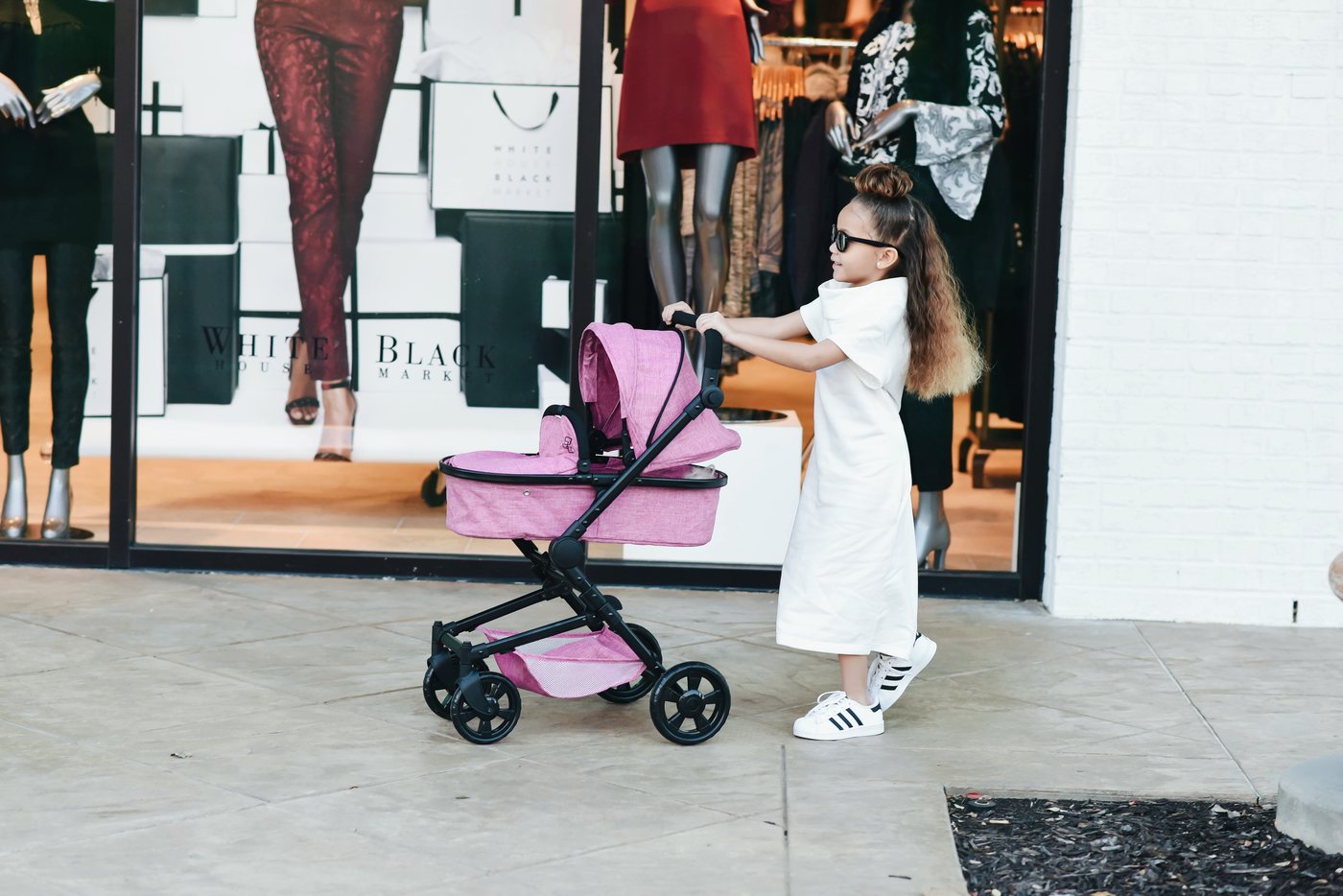 A young carer with her Triokid pram outside a boutique